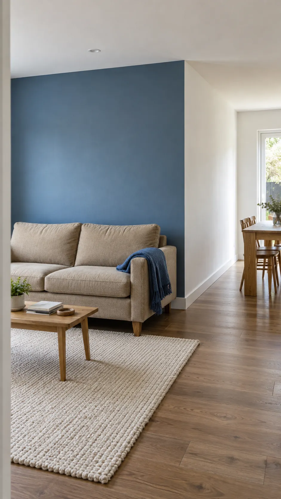 Denim blue living room wall ending at a real corner beside a white dining area
