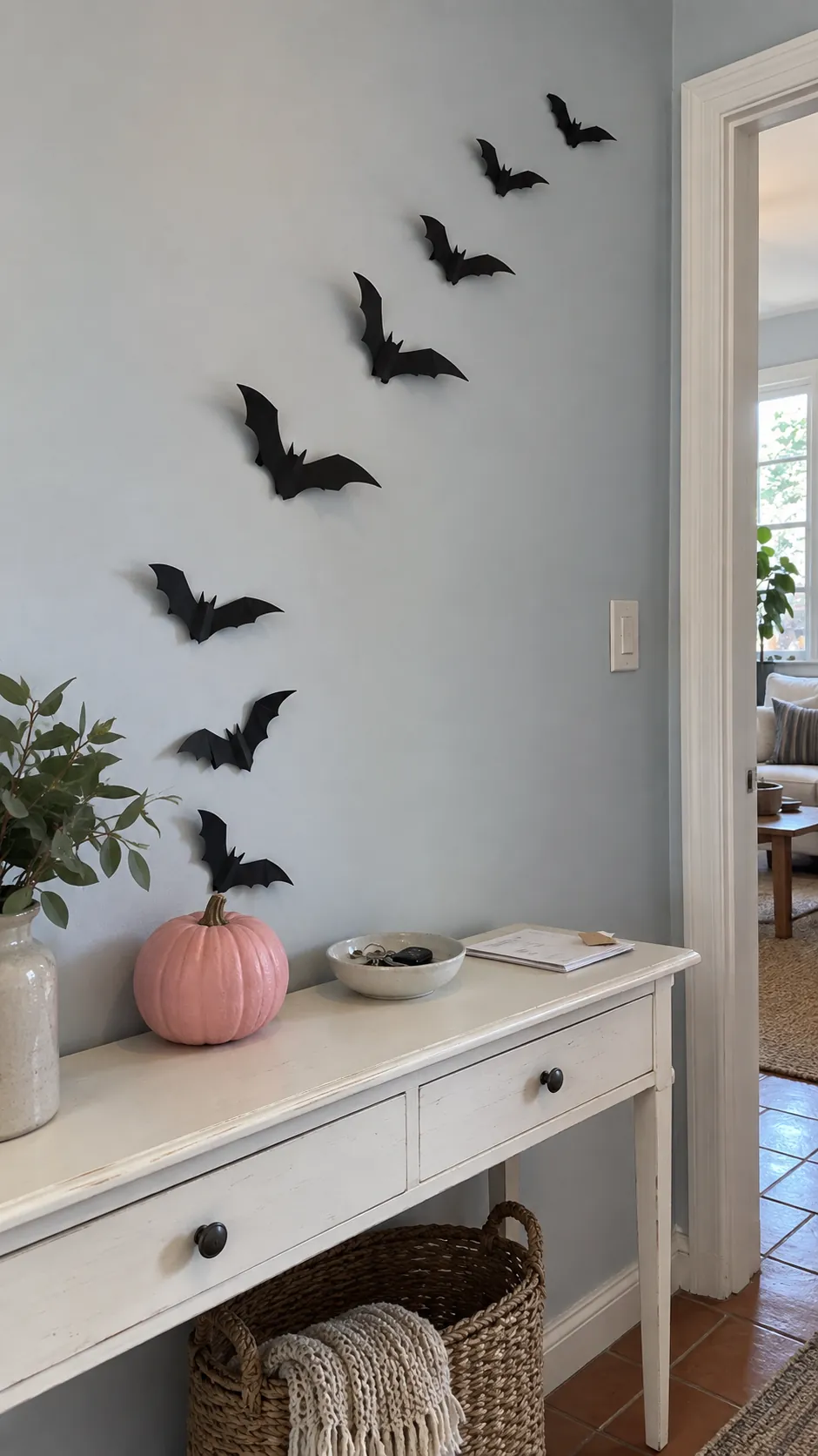 A bat flight over the entry table in black and pink Halloween decor