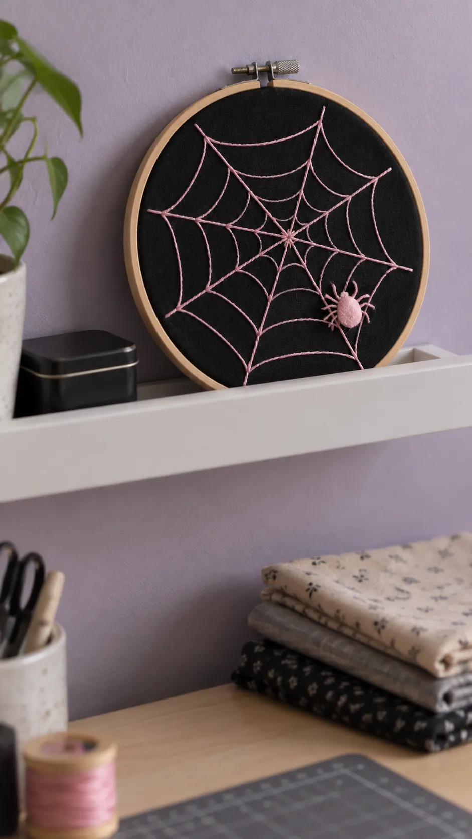 A spiderweb embroidery hoop in black and pink Halloween decor
