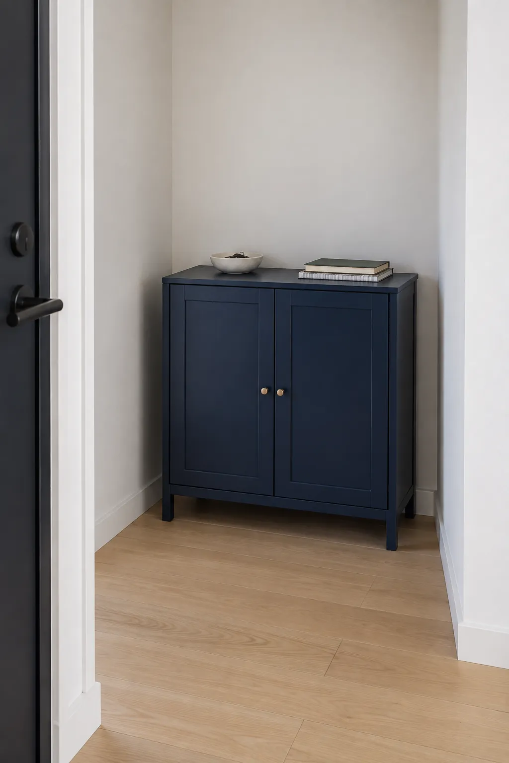 Simple navy cabinet furnishing an apartment alcove without clutter
