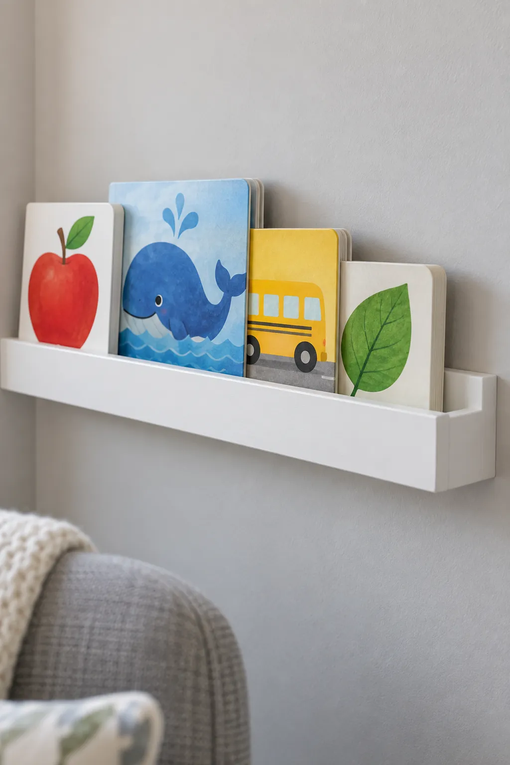 Small selection of board books held securely on a nursery book ledge