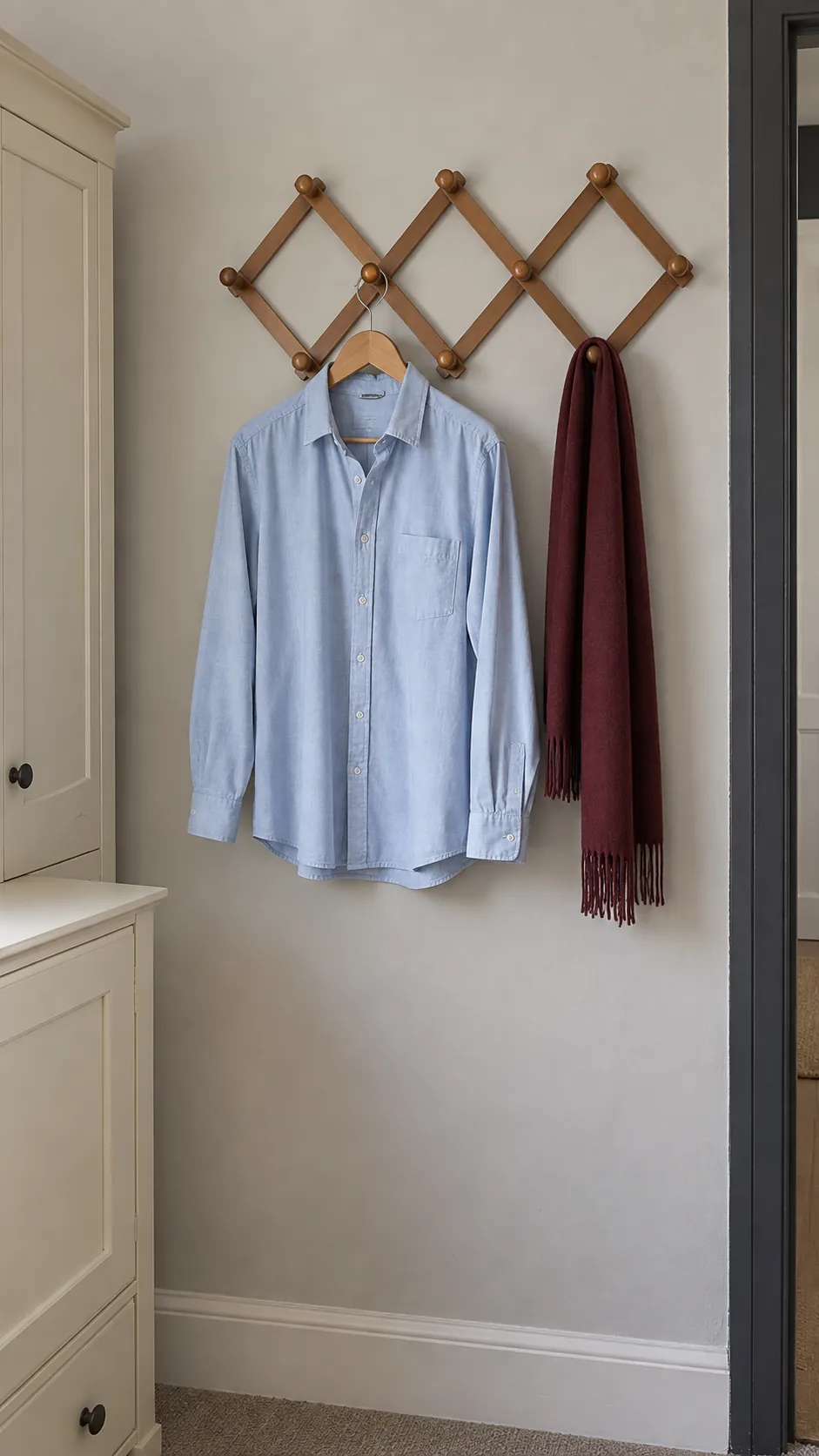 Wooden accordion rack holding a light shirt and scarf