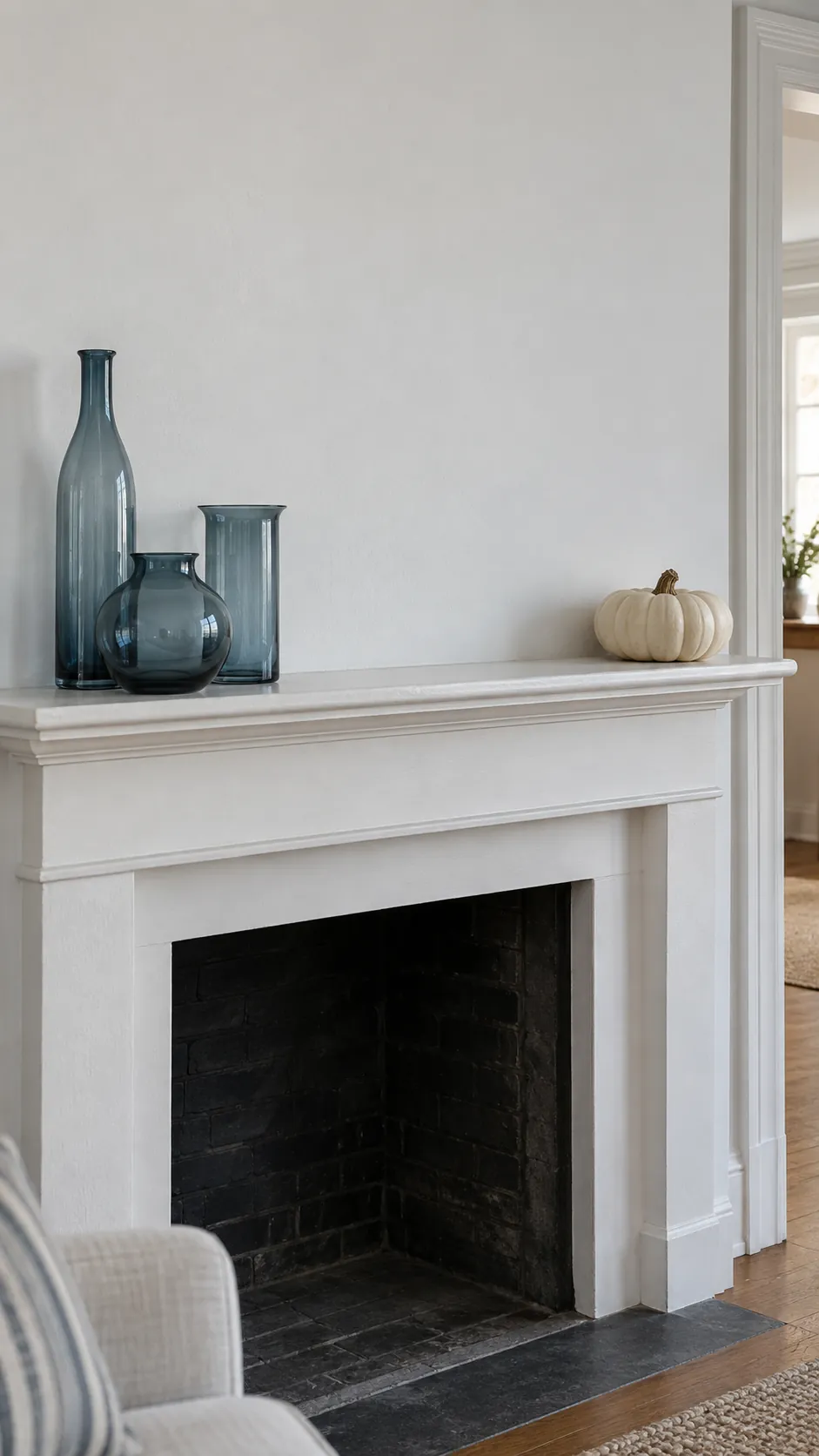Smoky glass vessels on a narrow mantel for coastal fall decor