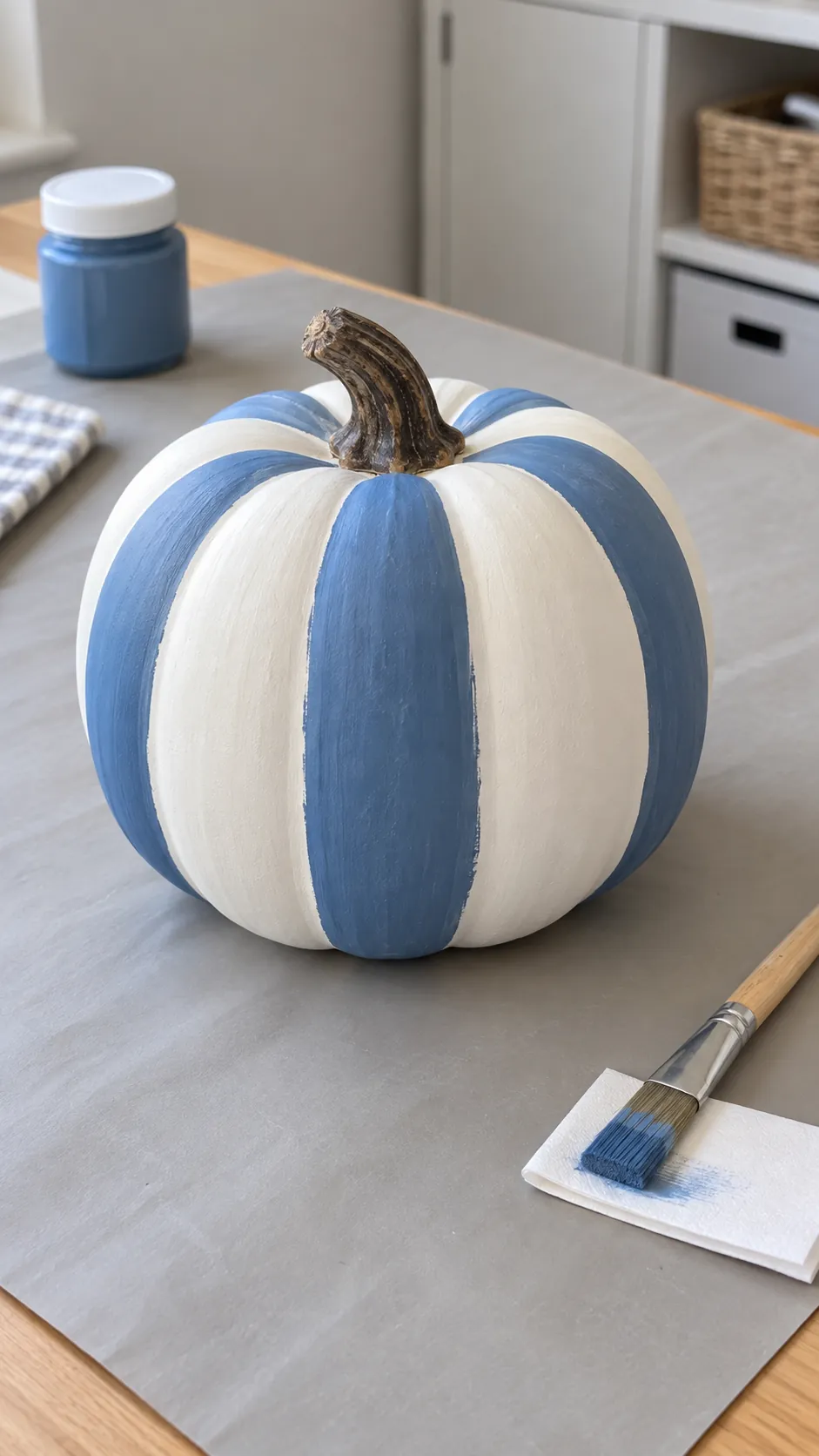 A painted pumpkin with a simple blue stripe for coastal fall decor