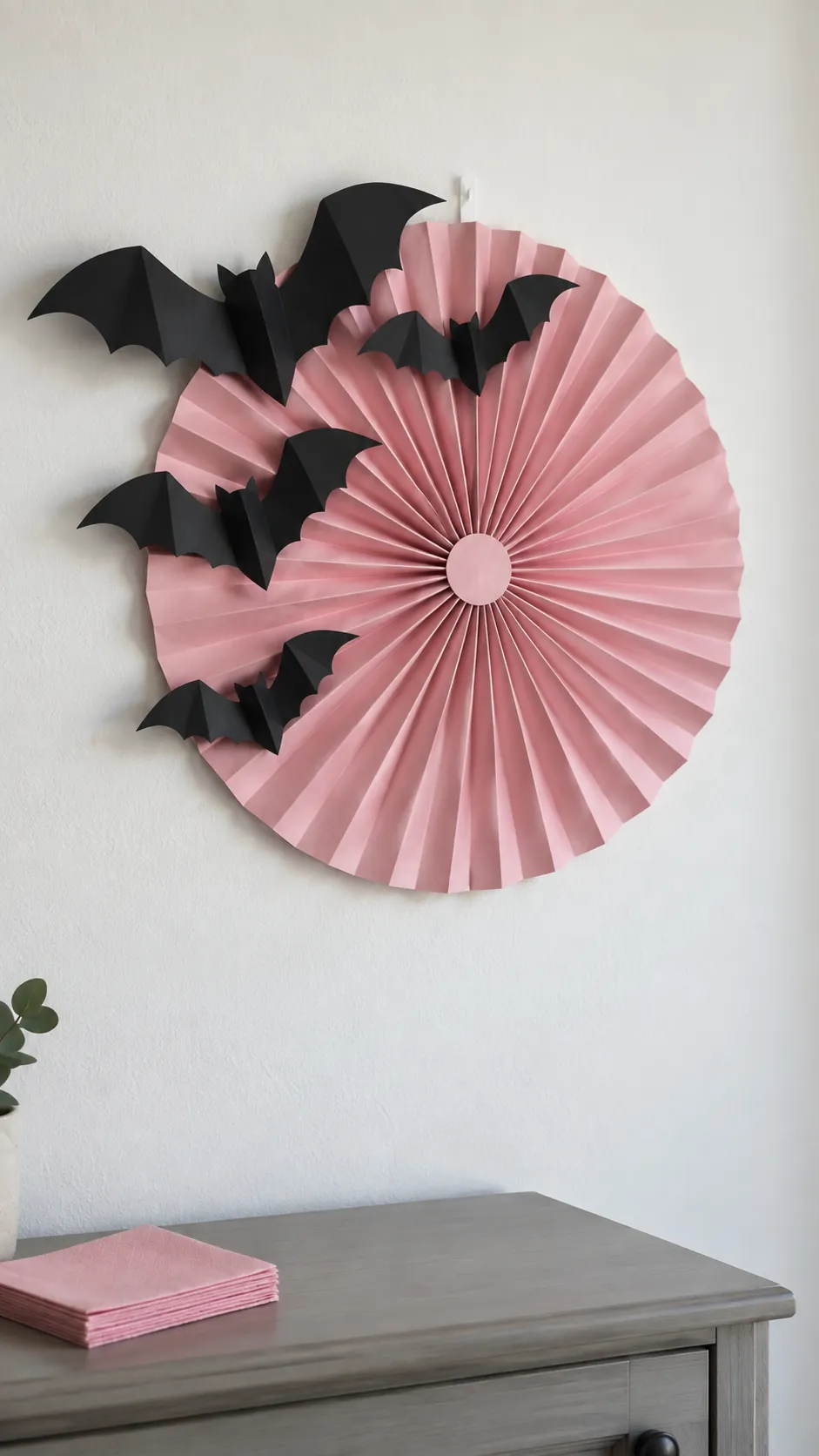 Black bats across a pink paper fan for a pink Halloween birthday party
