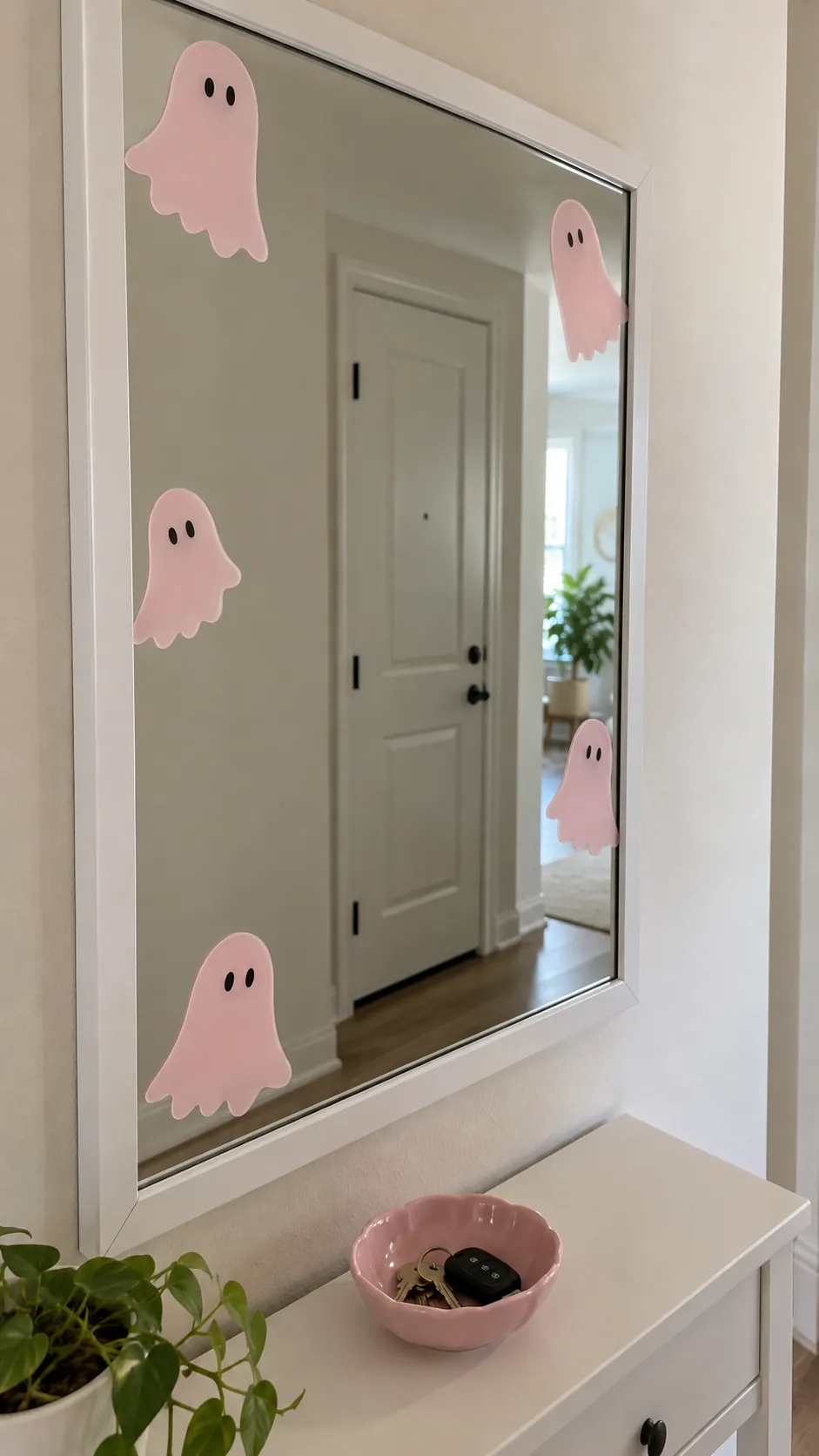 A mirror with removable pink ghost shapes for a pink Halloween birthday party