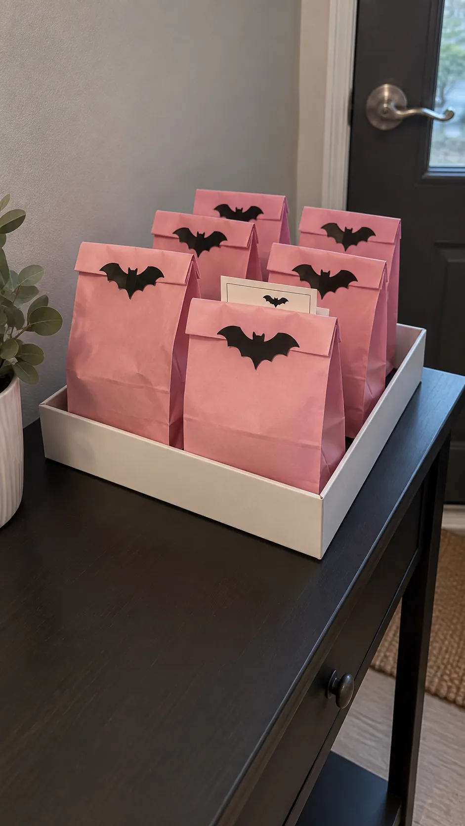 Favor bags with simple bat seals for a pink Halloween birthday party