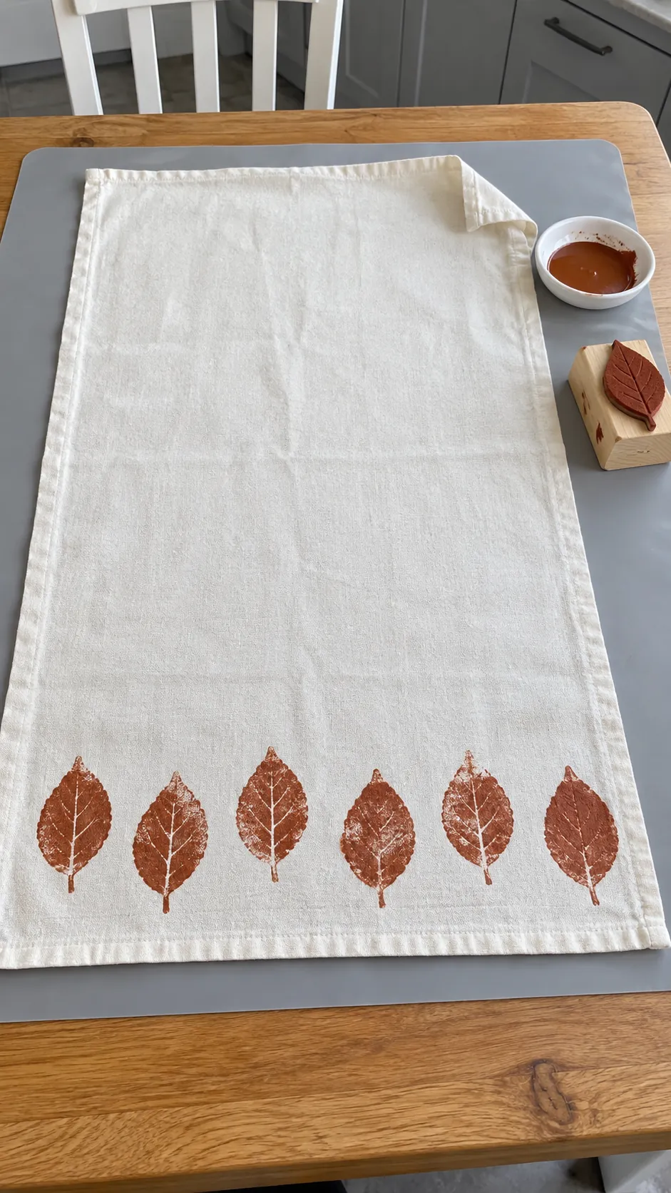 Stamp a washable towel with a simple leaf shape for homemade fall kitchen decor