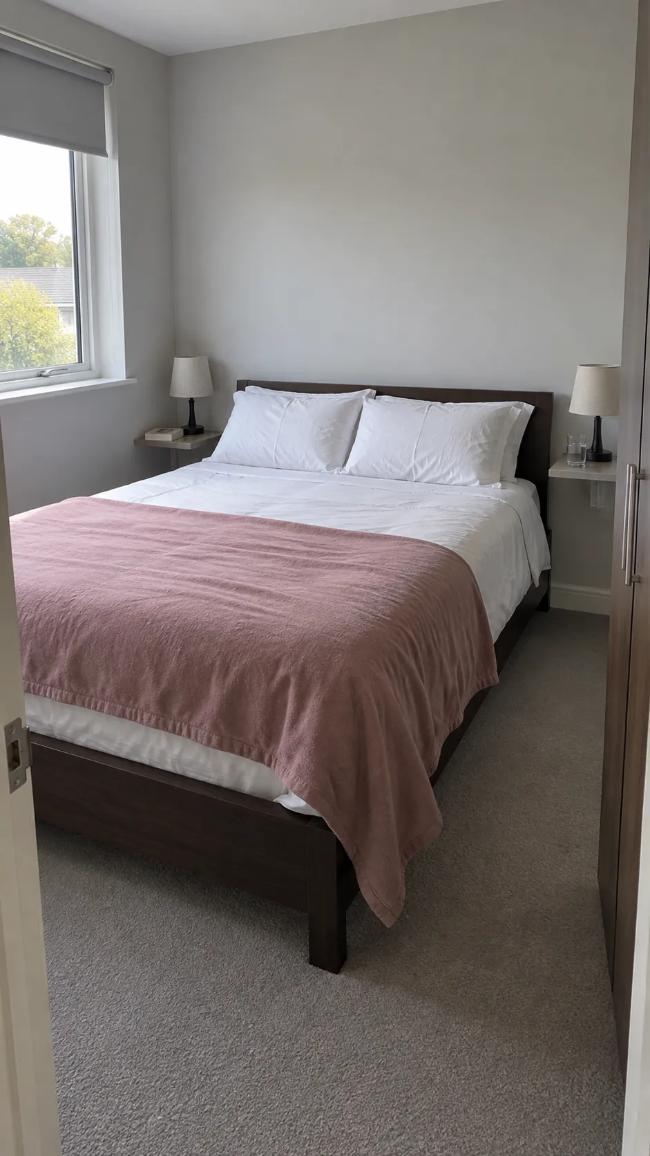 Small bedroom with narrow bedside shelves and accessible wardrobe
