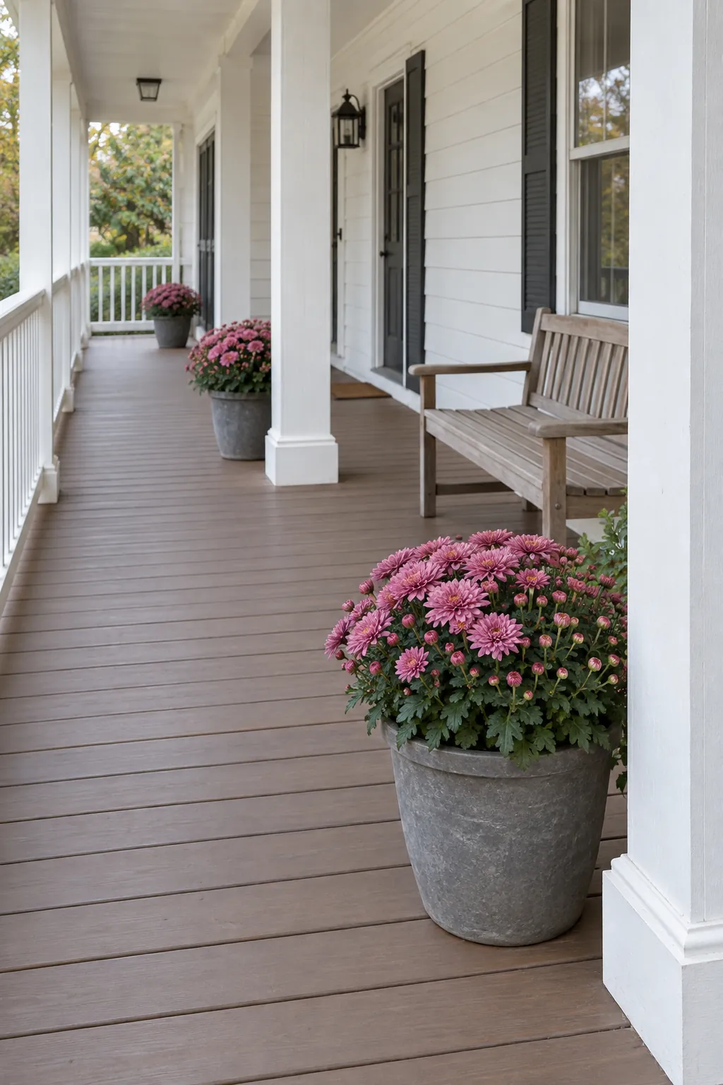 A restrained color repeat along a long porch with fall mums on a front porch