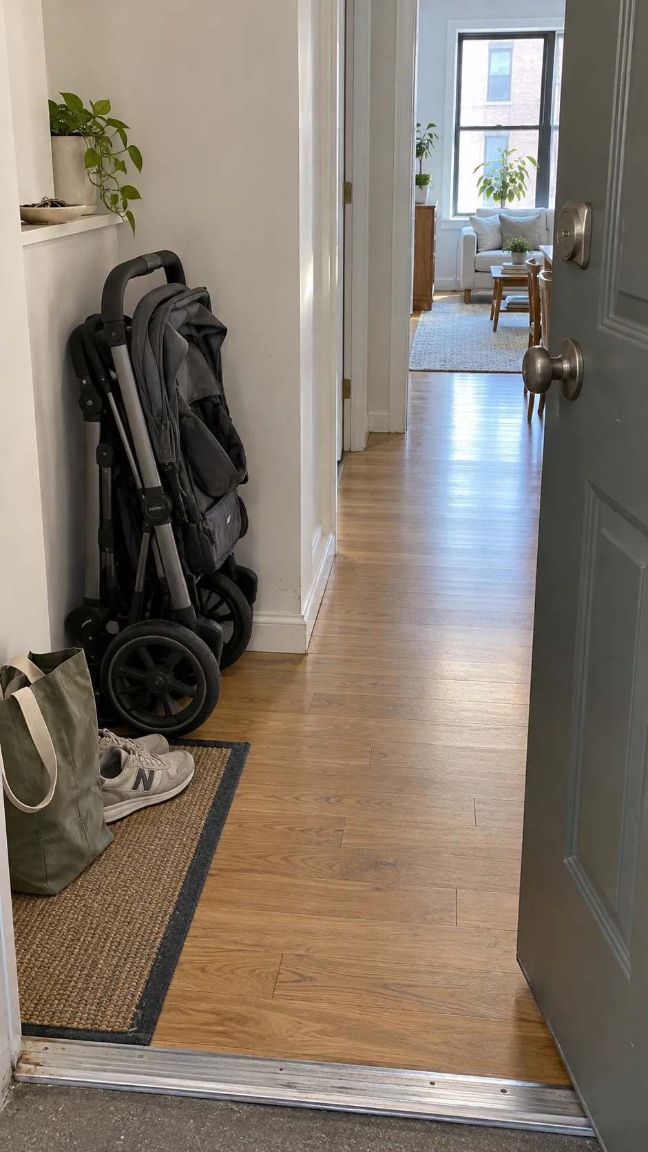 Folded stroller beside an apartment entry with a clear walking path