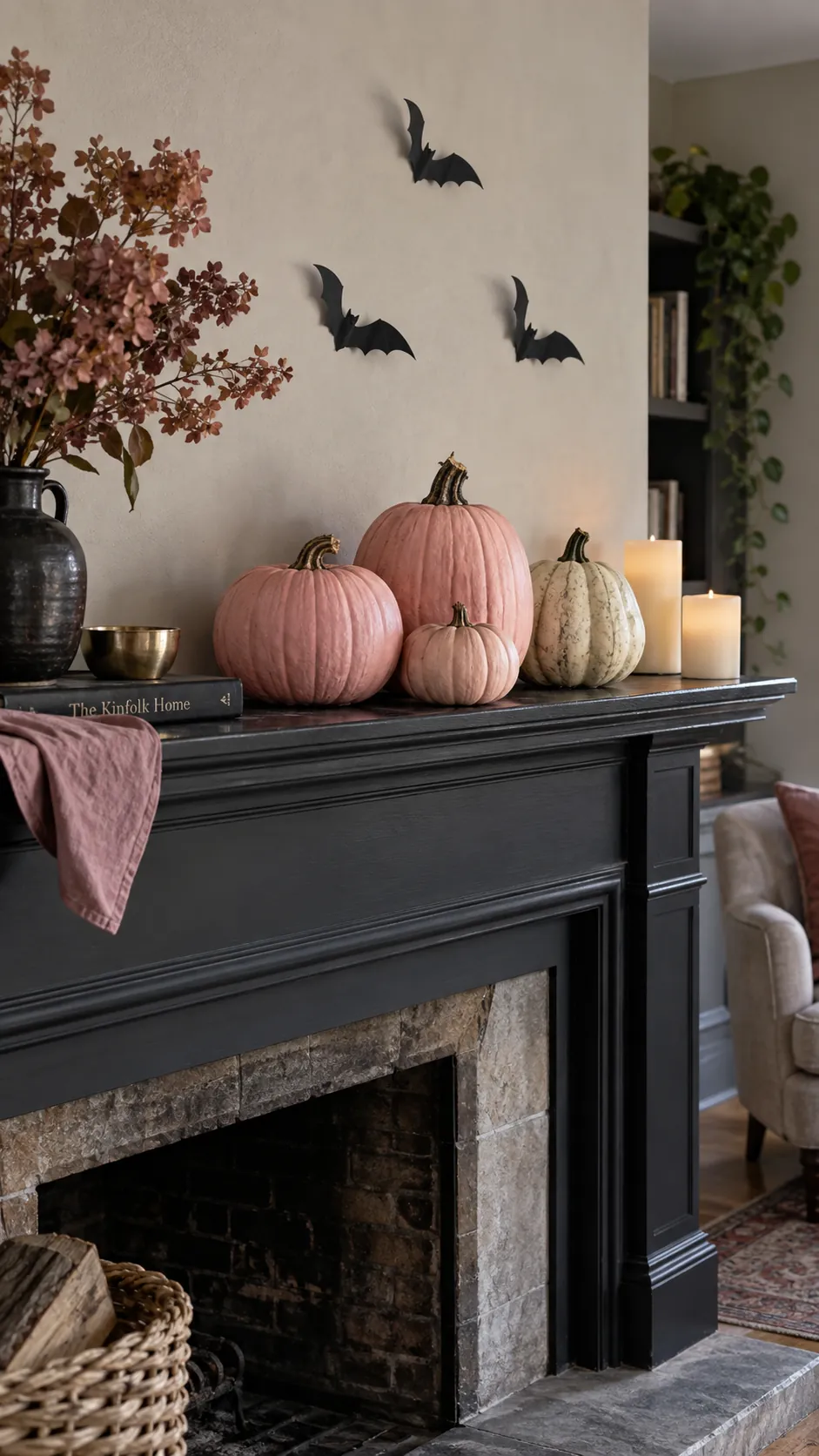 Pink and black Halloween decor with three uneven blush pumpkins, one natural pale squash, and a few small black paper bats