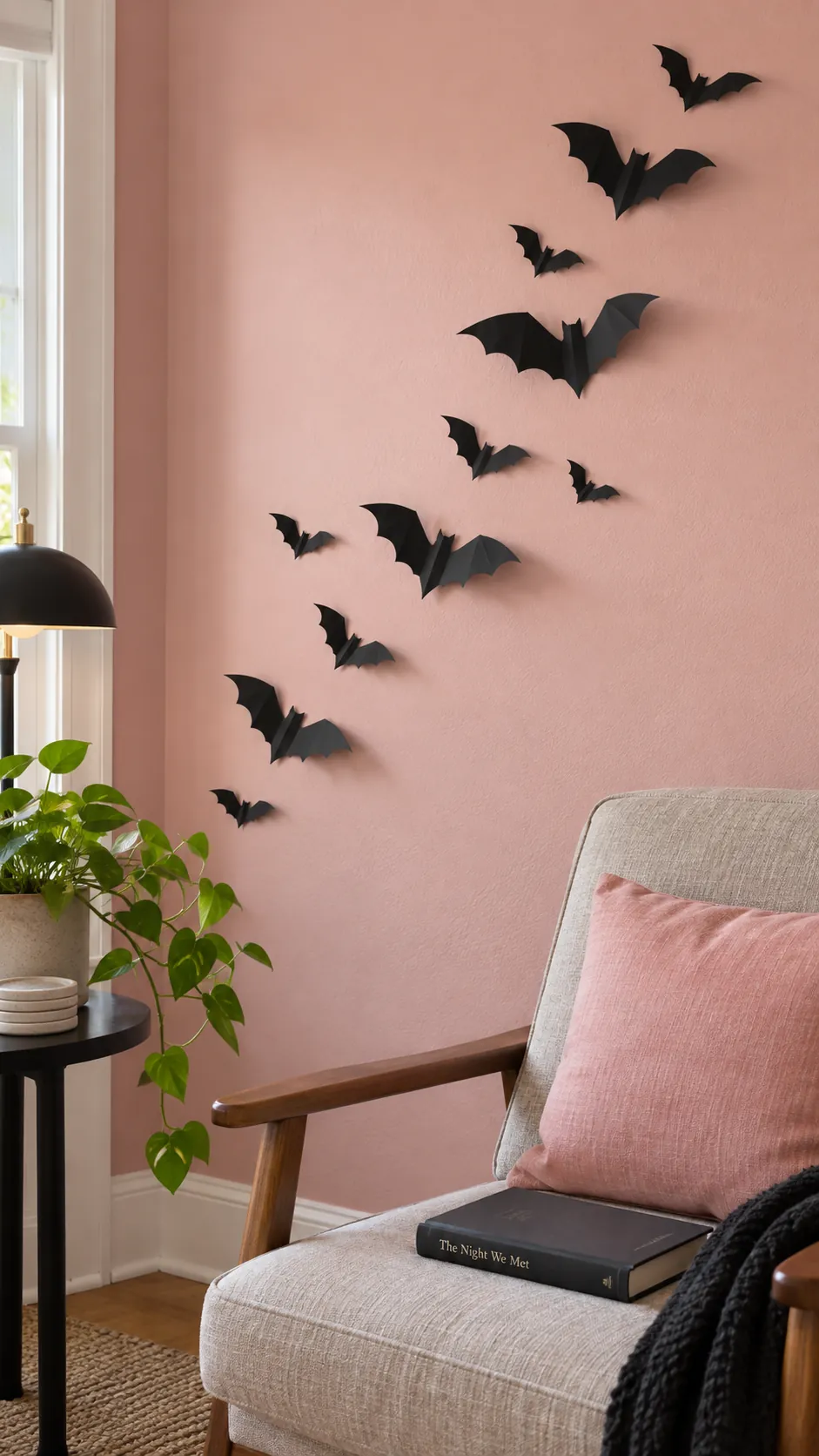 Pink and black Halloween decor with a loose upward trail of individually folded matte black paper bats in multiple sizes