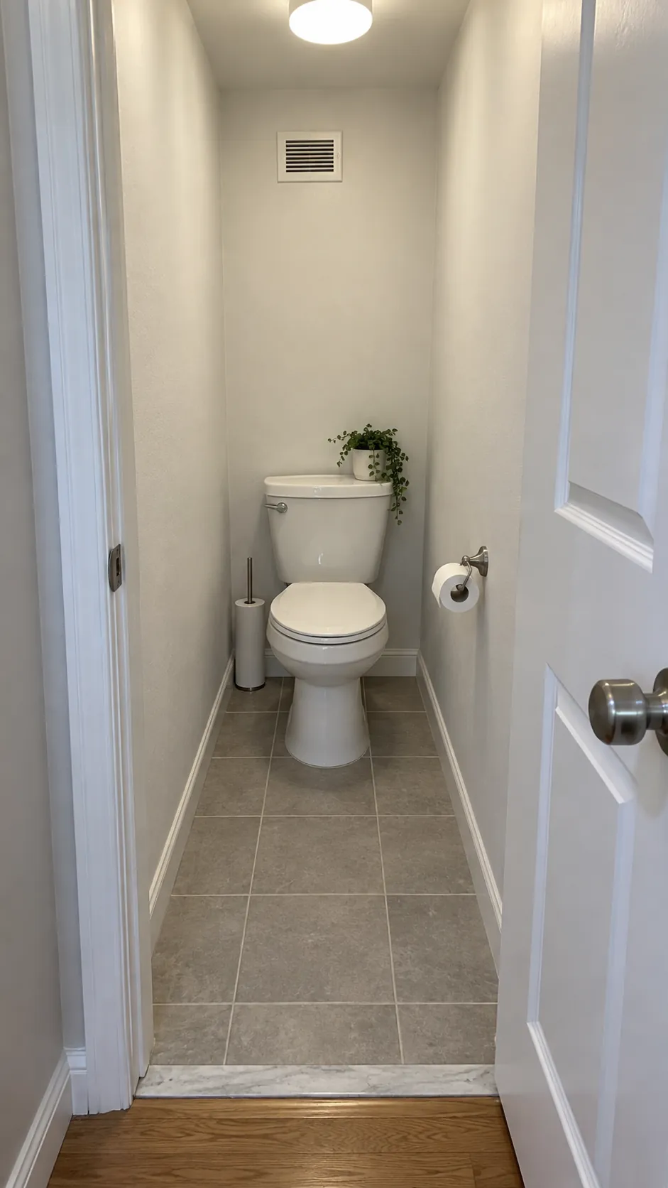 Tiny toilet closet with a clear doorway and uncluttered floor