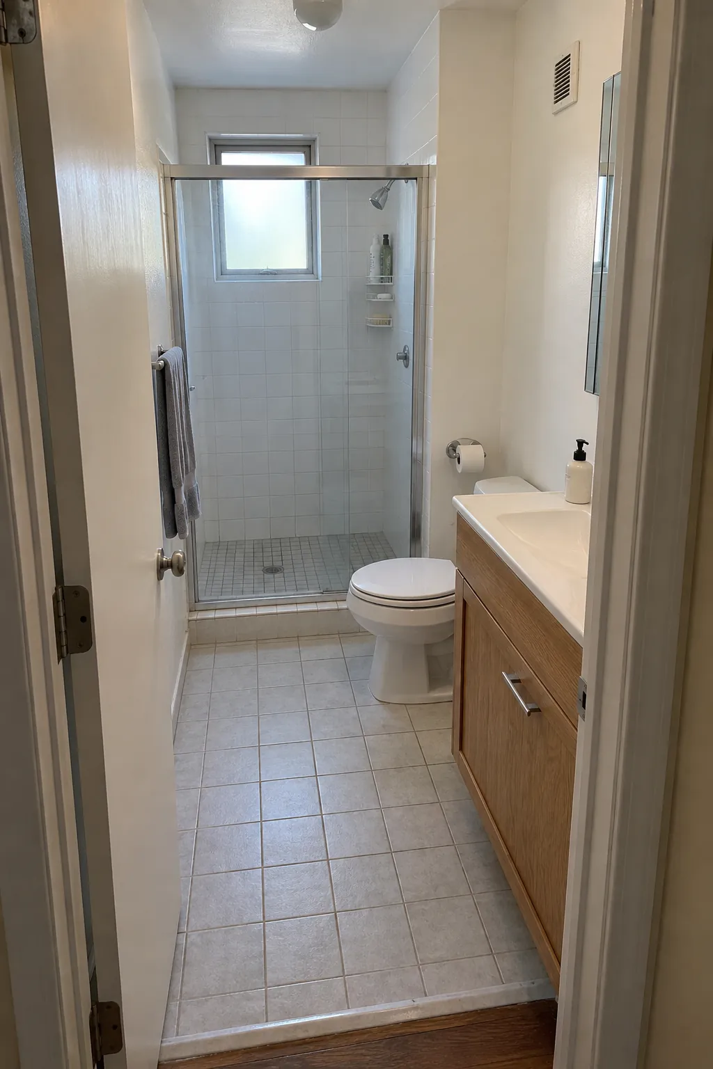 Compact bathroom with visible door fixtures and clear central floor area