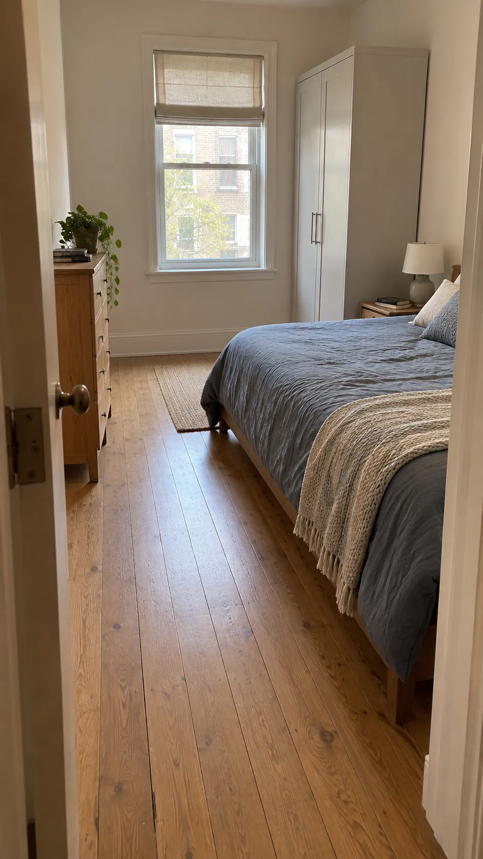 Clear doorway sightline across a compact bedroom toward a window