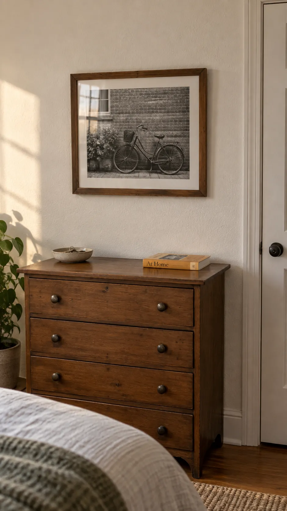 Personal framed print above a small bedroom dresser
