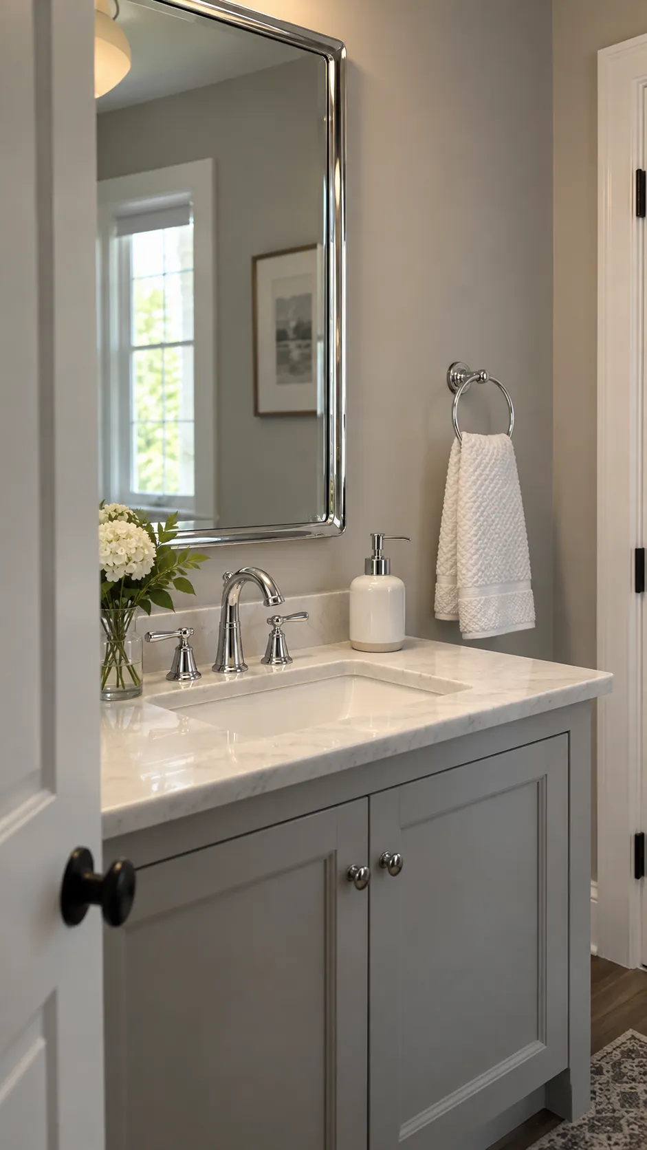 Coordinated chrome fixtures and practical accessories in a compact powder room