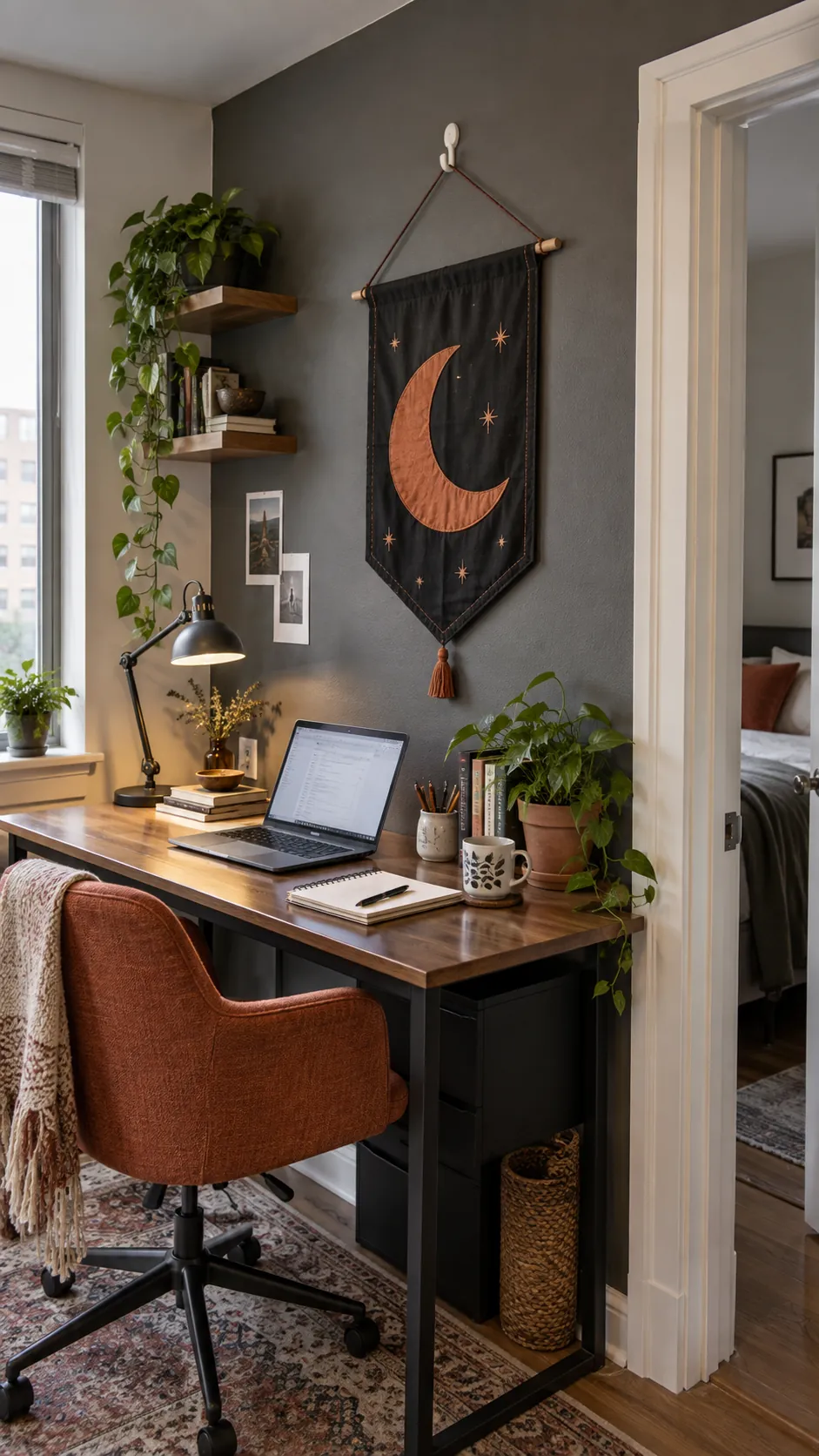 A fabric banner above the desk in a small studio apartment