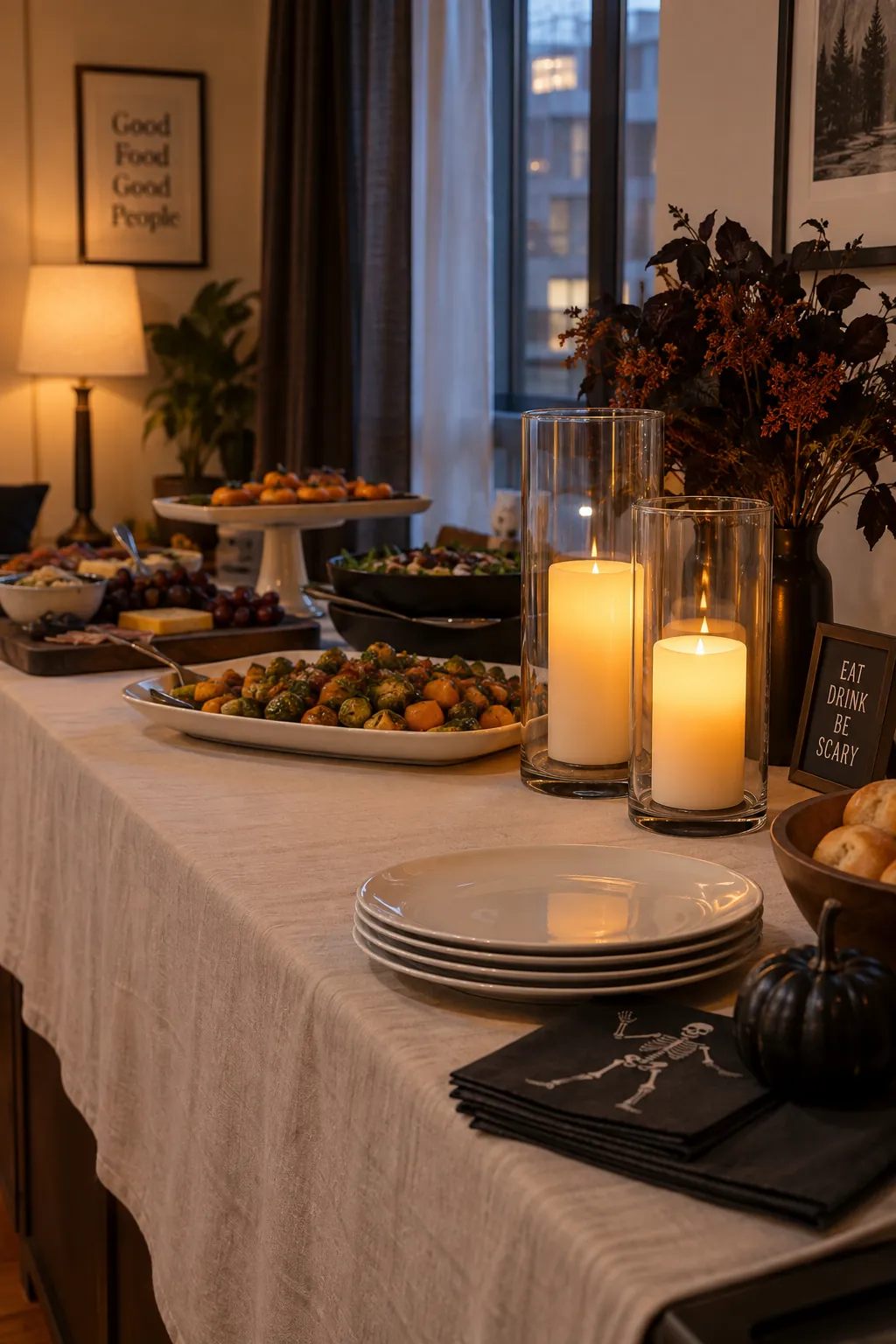 Battery candles in clear hurricanes at the end of a Halloween serving table