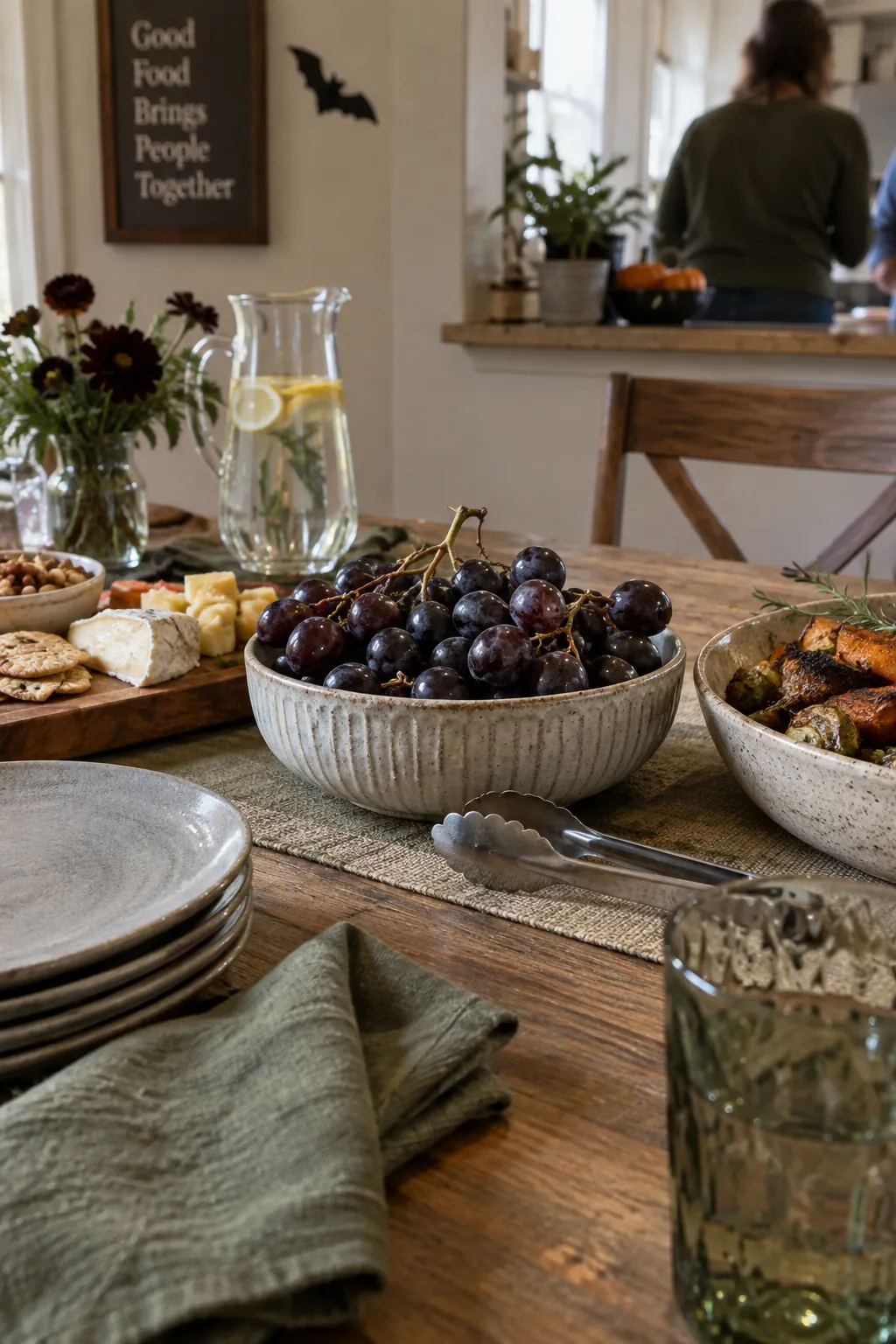 Low ceramic bowl of dark grapes used as Halloween table decor