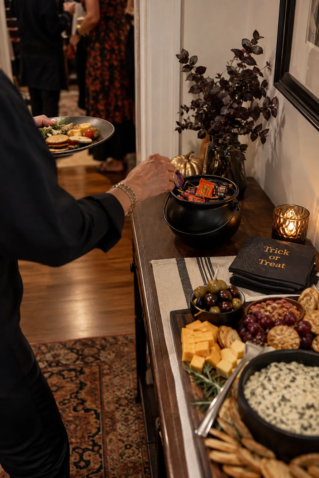 Small black cauldron filled with wrapped Halloween treats on a buffet