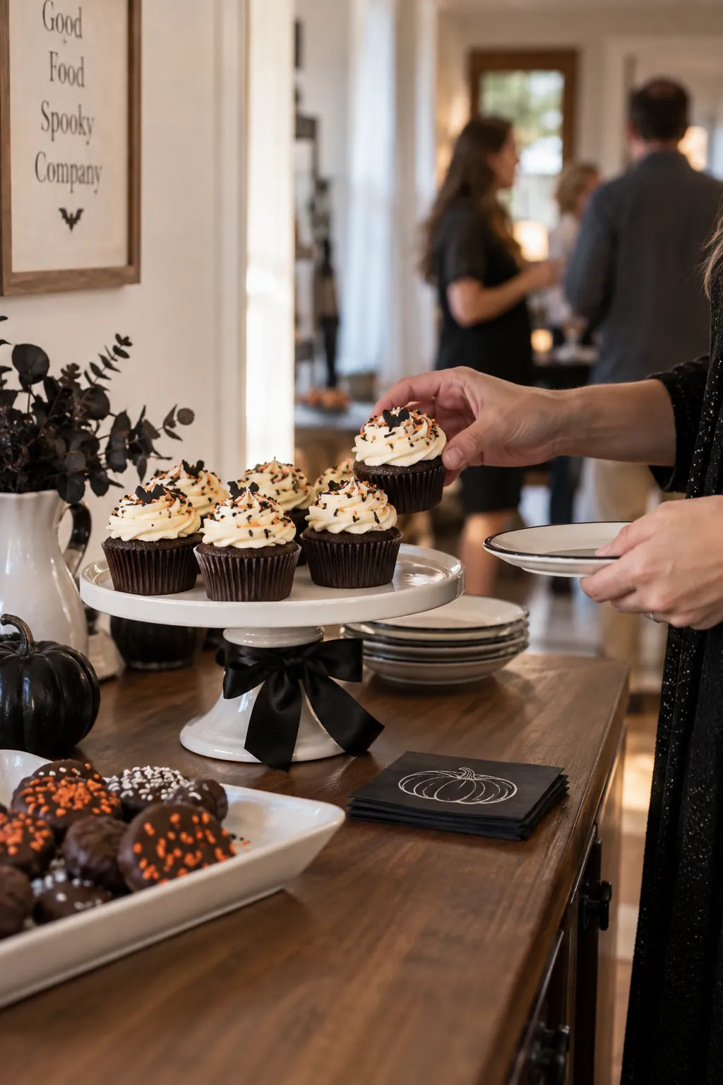 Black ribbon tied around a cake stand holding Halloween cupcakes