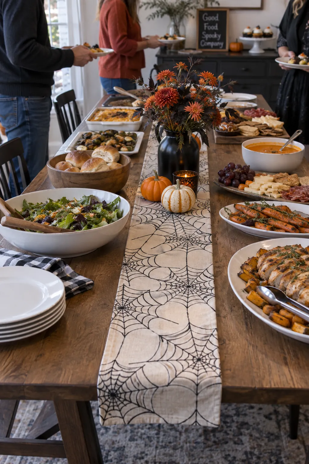 Narrow spiderweb patterned runner between Halloween party dishes