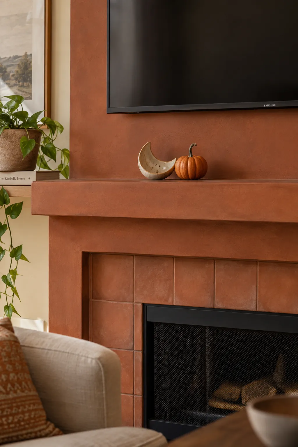 Stoneware moon dish beside a single small pumpkin on a TV mantel