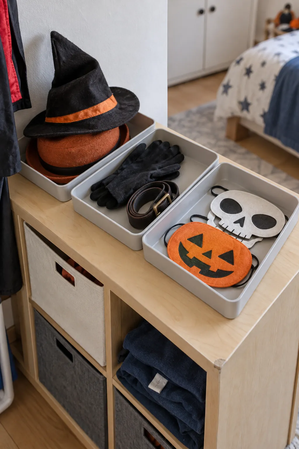 Shallow trays sorting Halloween costume hats masks and gloves in a compact bedroom
