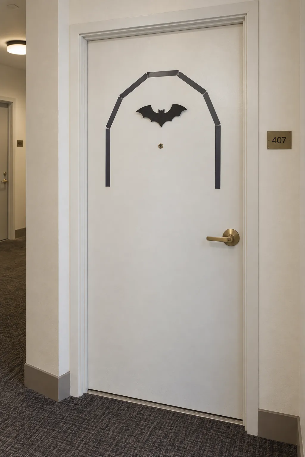 Removable geometric tape arch around a bat shape on an apartment door