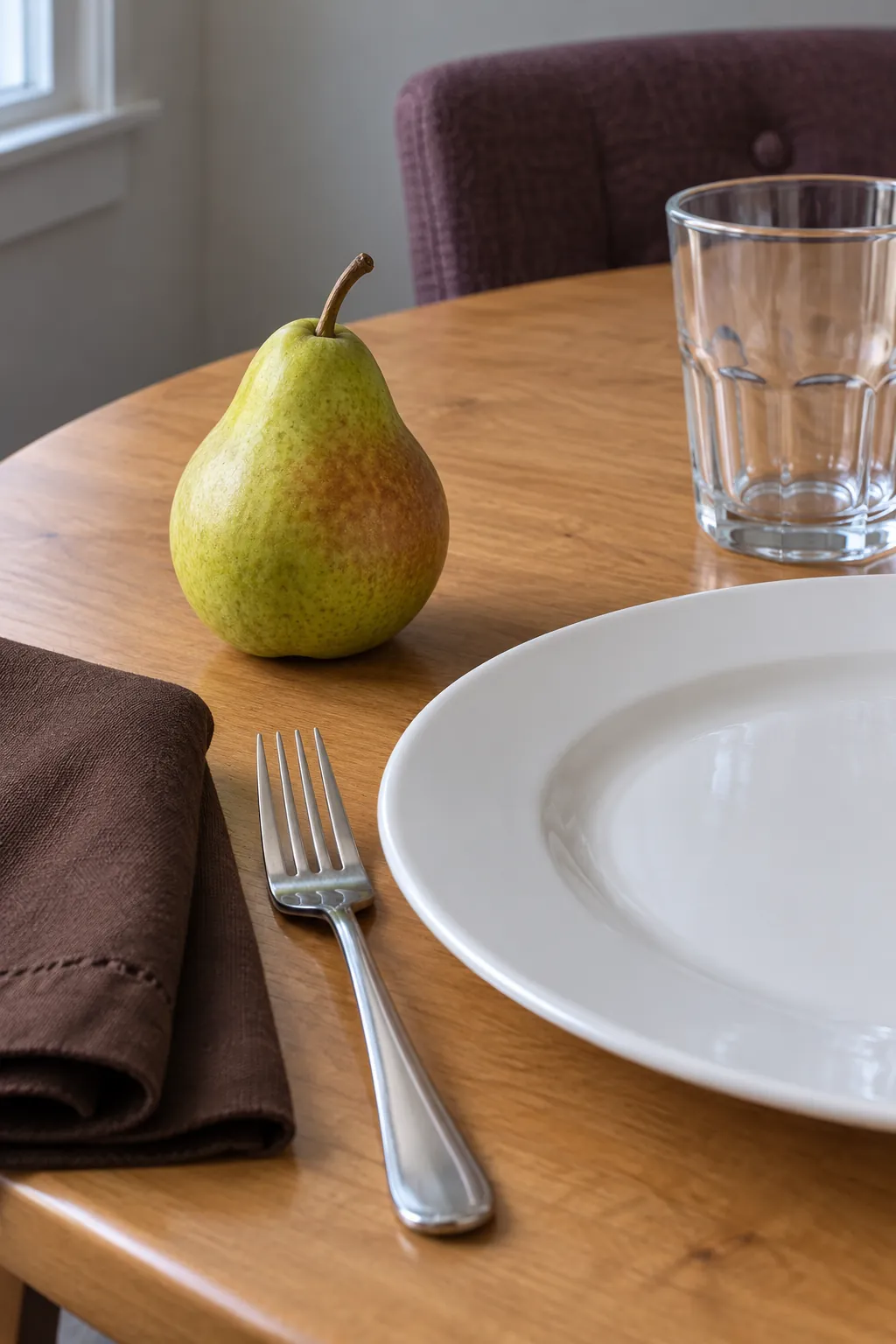A whole pear at the outer corner with everyday white dishes