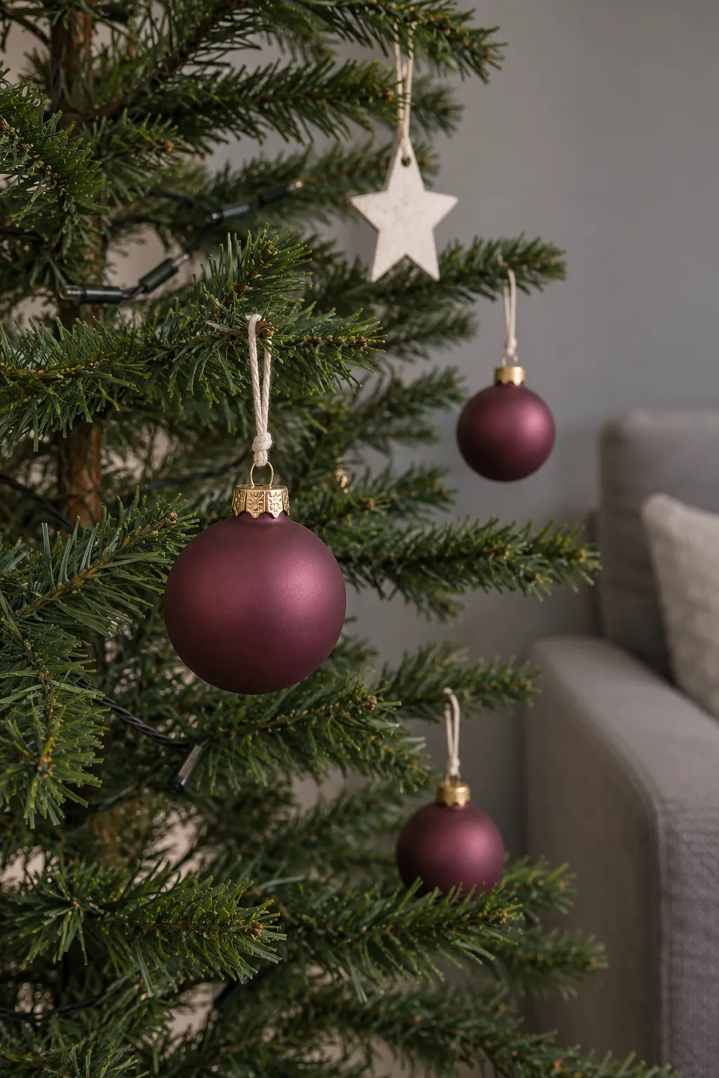 Small ornaments spaced on a slim tree with clear branch tips