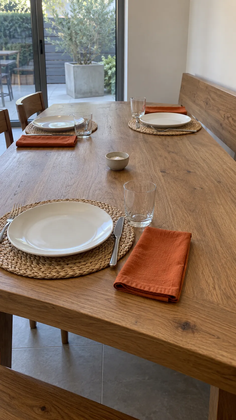 Thanksgiving tablescape featuring burnt orange napkins on a bare table