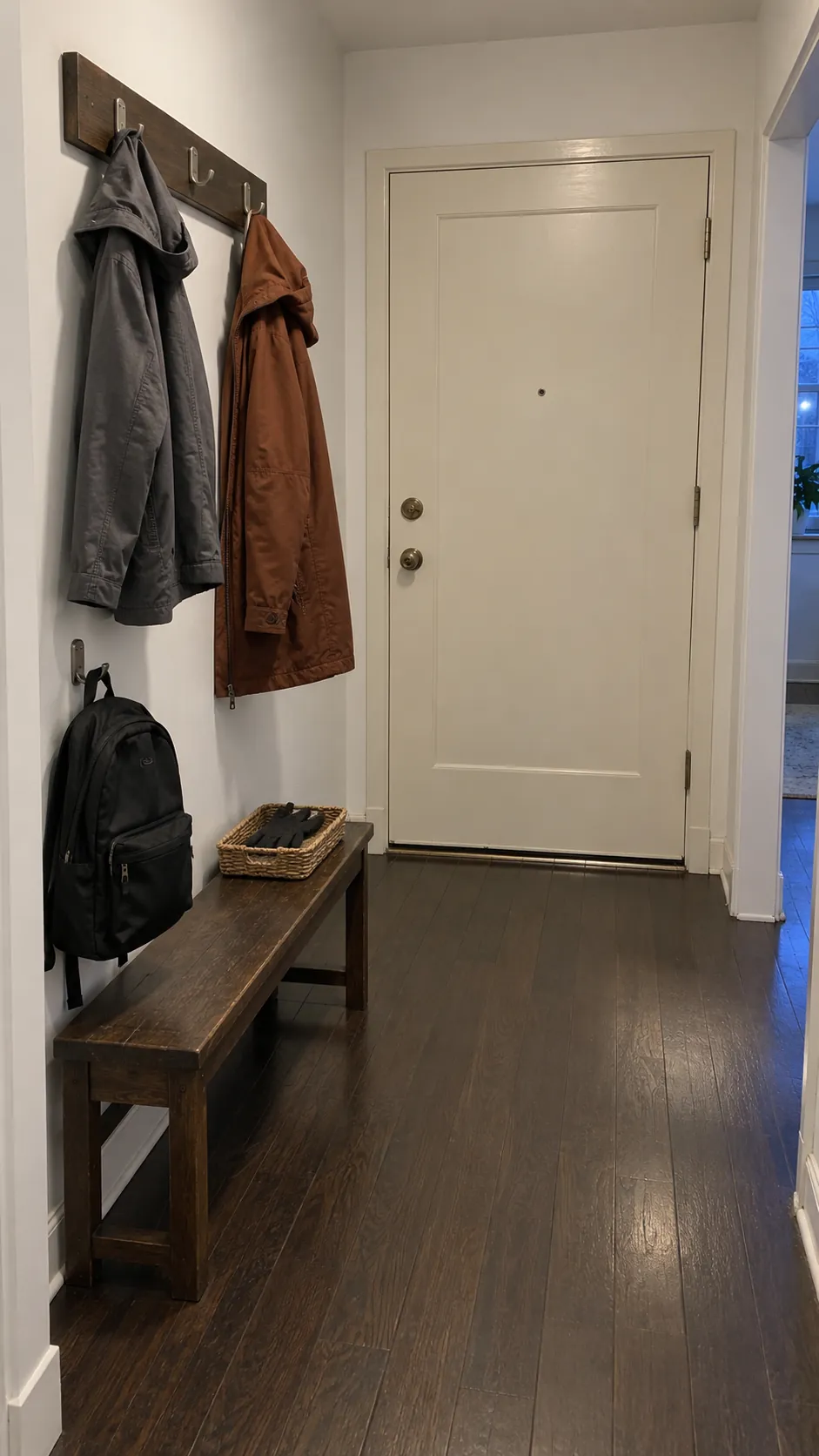 A clear foyer with only daily coats and bags on the rack