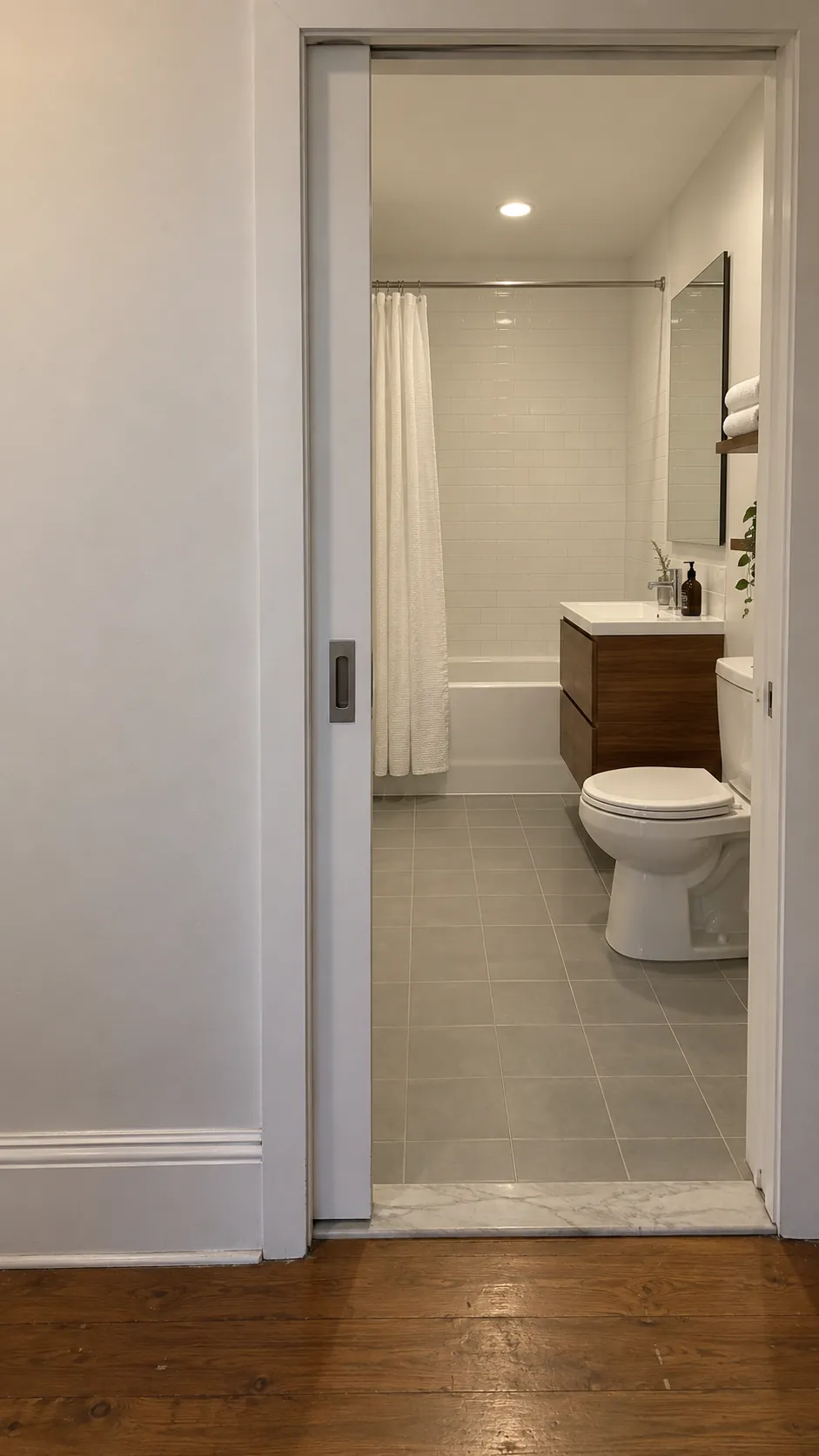 Photograph the relationship between a practical pocket entrance and a retained end wall tub, making the door cavity location intelligible through real physical details.