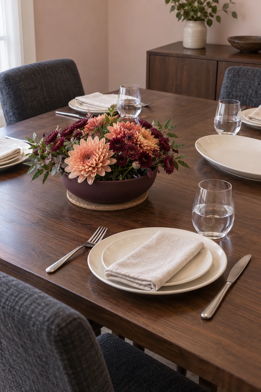 A low bowl of seasonal flowers on a protective base for an elegant but practical Thanksgiving table.