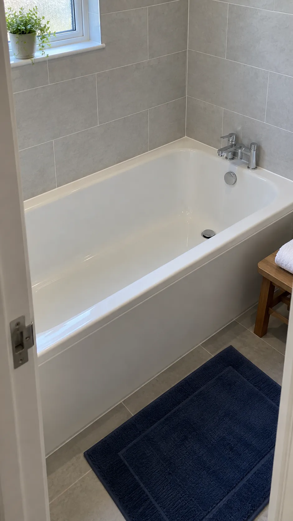 Replacement bath with its drain end retained in a small bathroom