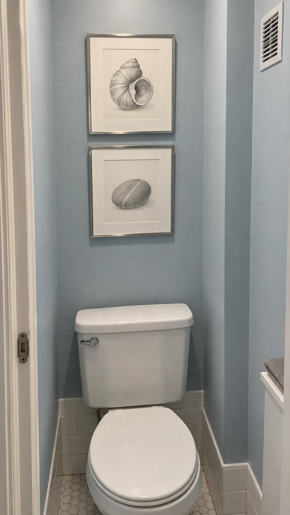A slim pair of stacked sketches above a powder room toilet