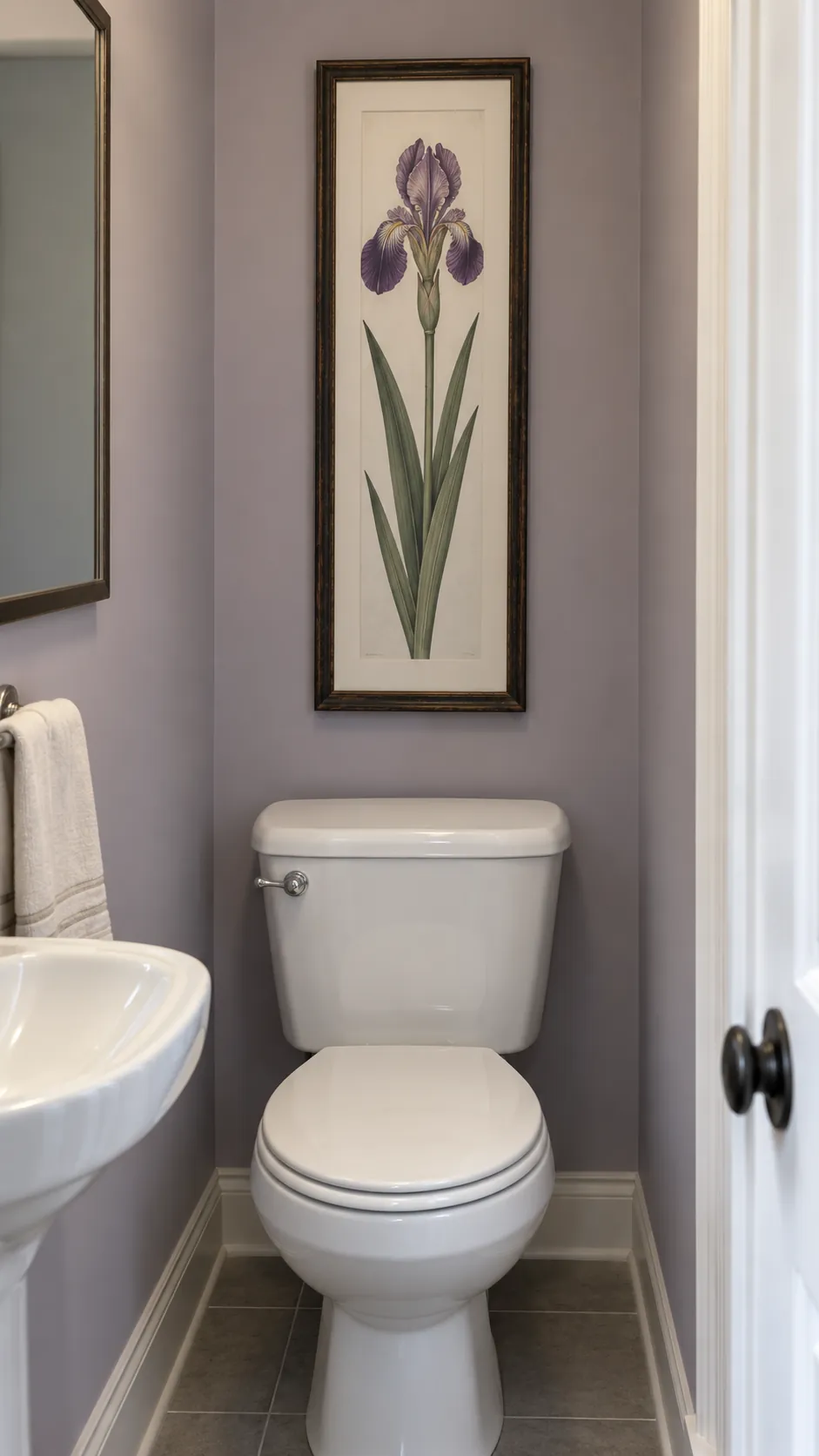 A narrow vintage floral study above a powder room toilet