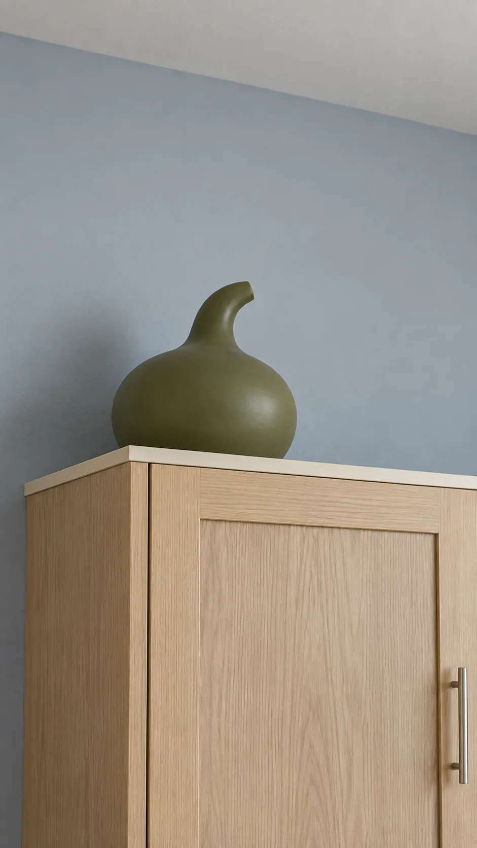 One stable matte olive decorative gourd on a short kitchen cabinet run