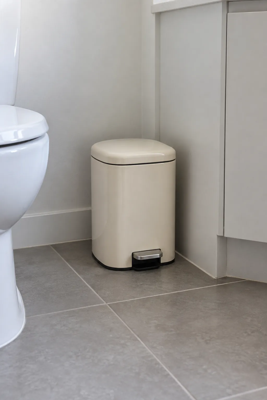 A compact lidded bin with room to open in a rental powder room