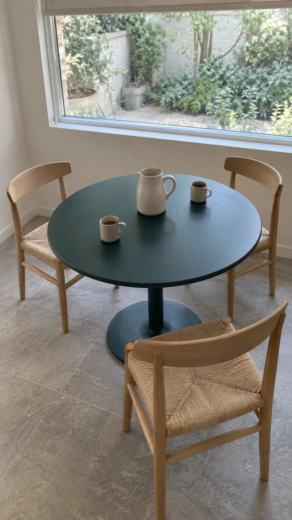 Round pedestal dining table with separate chairs around its curved edge