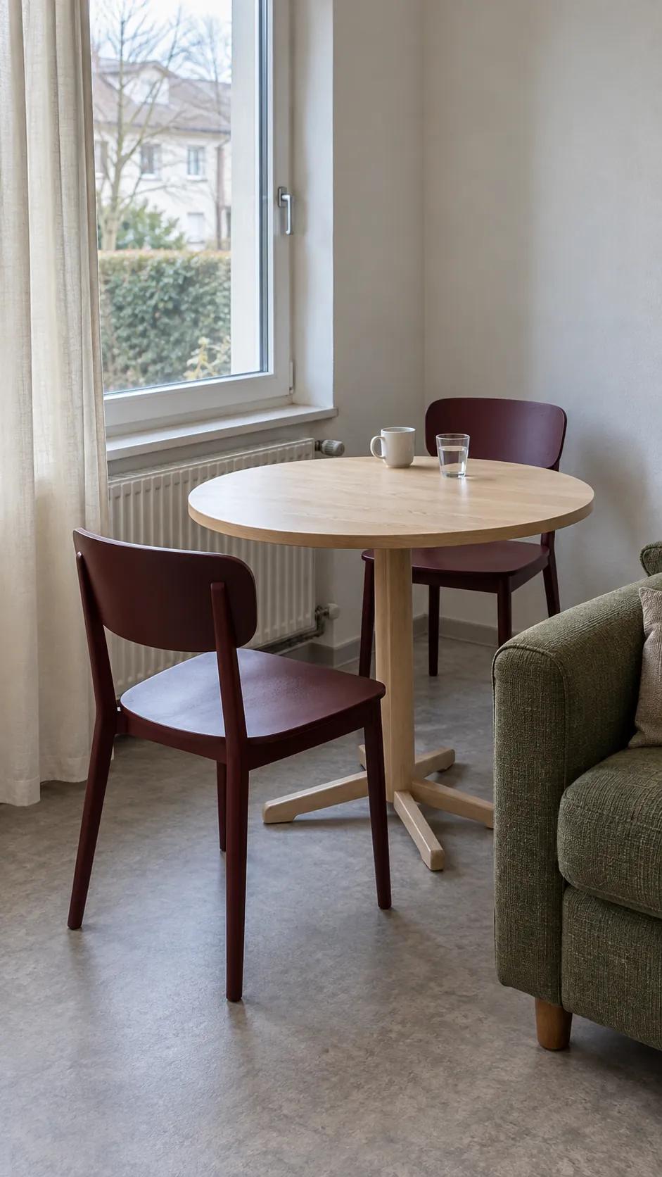 Small round dining table near a living room window