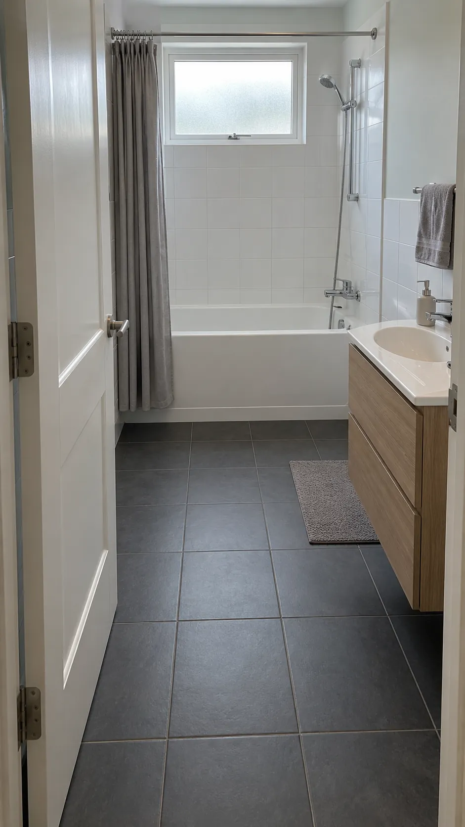 Small bathroom bath entry route beside a compact vanity