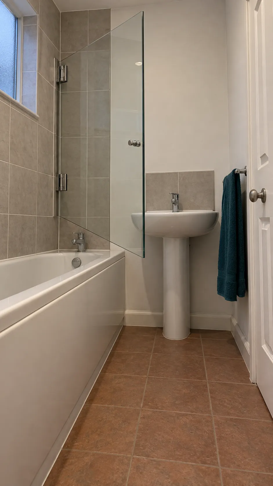 Hinged bath screen beside a clear floor space