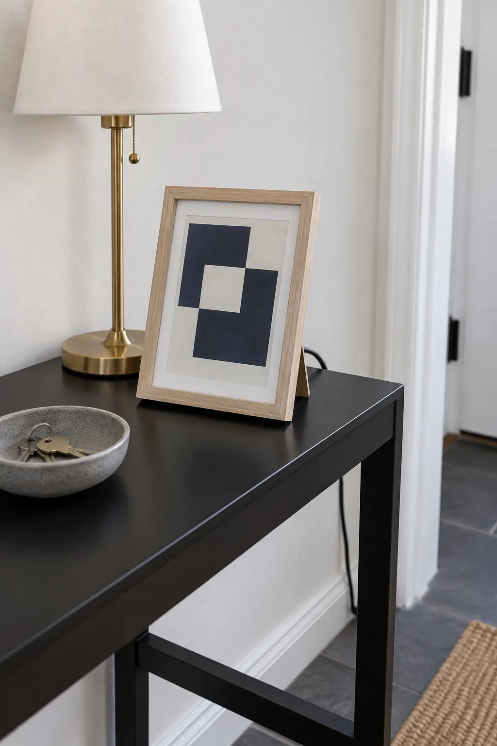 Set a Small Frame Beside the Lamp in an entryway lamp and console arrangement