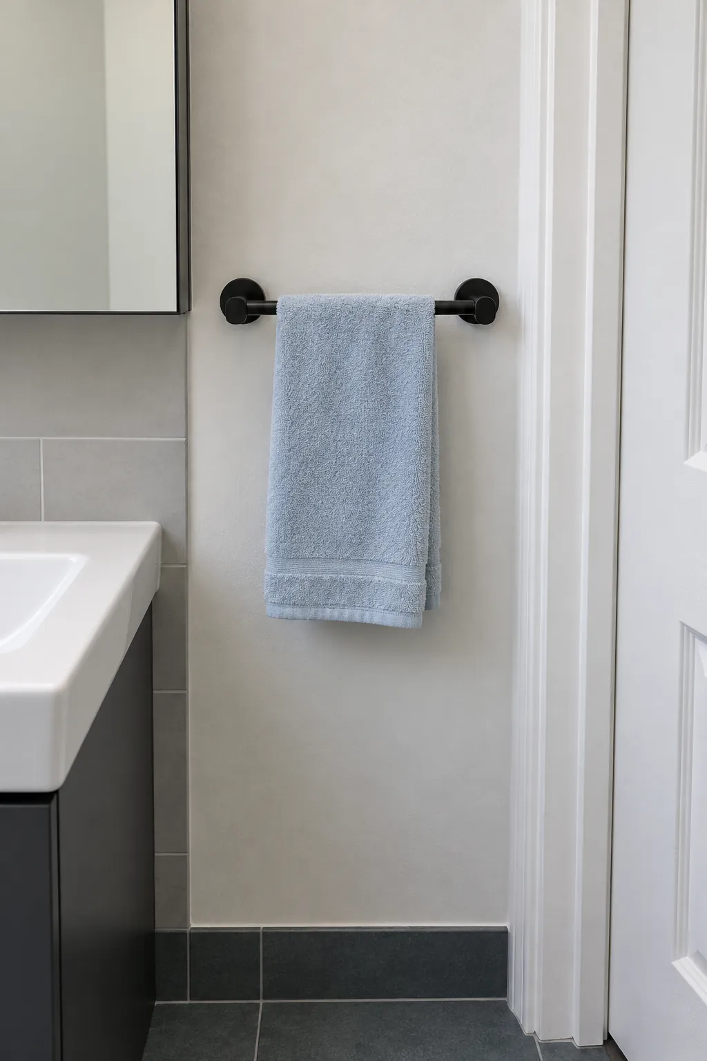 Short towel bar on a narrow clear bathroom wall strip