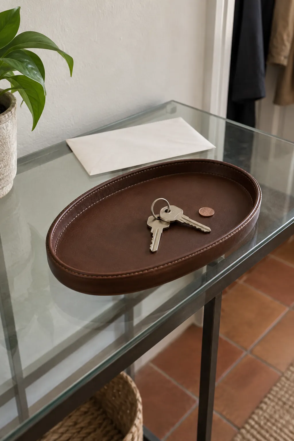 Opaque leather tray grouping keys on a glass console