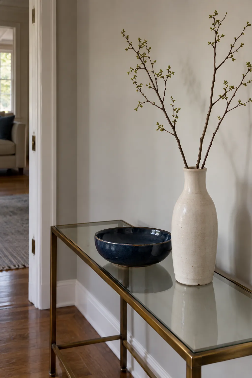 Tall ceramic vase and low indigo bowl on a glass console